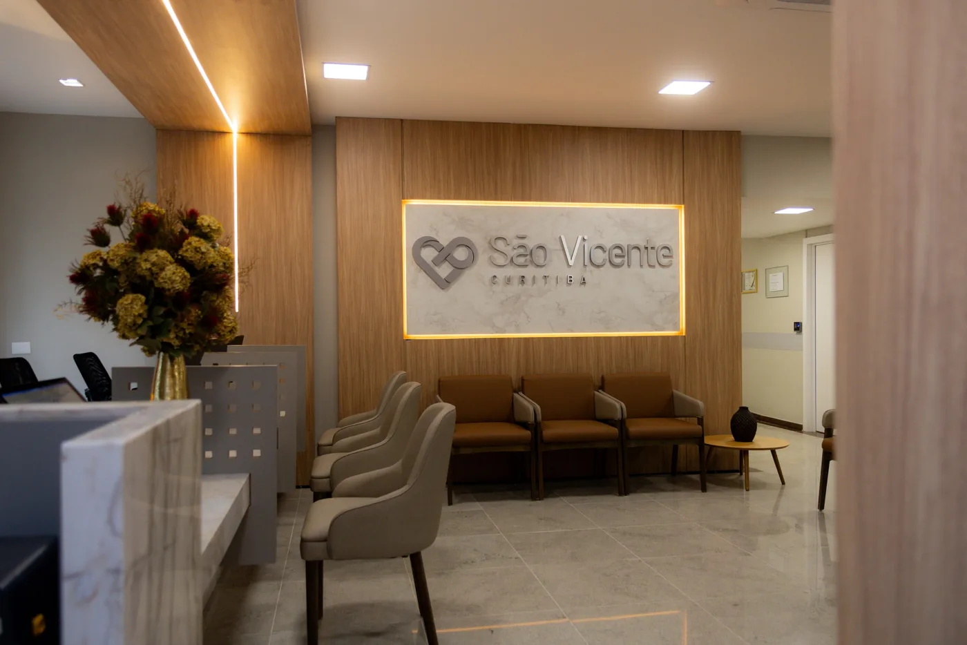Recepção com painel iluminado e poltronas de espera
